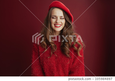 happy woman in red sweater and beret against red background happy woman in red sweater and beret against red background 105984897
