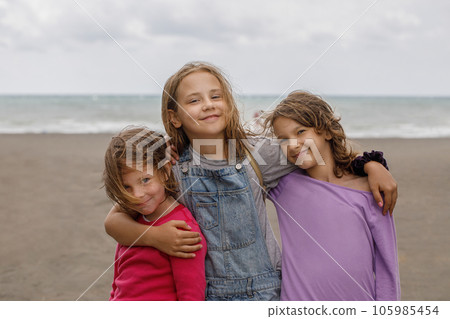 Attractive adorable young child girls hugging outdoor. Child 7, 8 and 10 years old portrait Attractive adorable young child girls hugging outdoor. Child 7, 8 and 10 years old portrait 105985454
