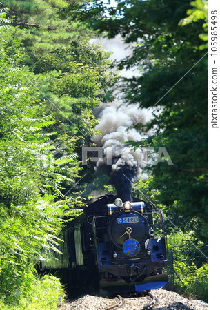 Uphill on the JR Kamaishi Line, SL Ginga C58239 steam locomotive blue with explosive smoke coming up the slope in front of Dosen Station towards the pass 105985498