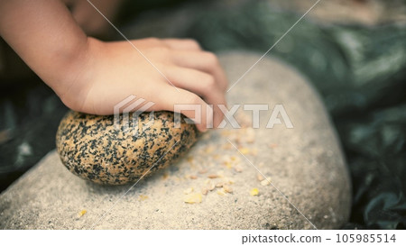 Little kid makes bread flour in a primitive historic way Little kid makes bread flour in a primitive historic way 105985514