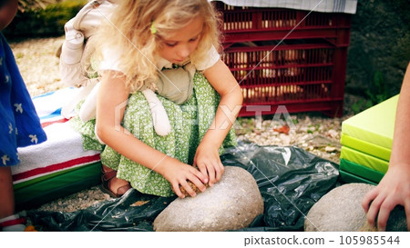 Little girl learns to make bread flour in a primitive historic way Little girl learns to make bread flour in a primitive historic way 105985544