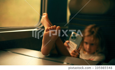 Little girl uses her smartphone whle traveling in the high-speed train 105985548