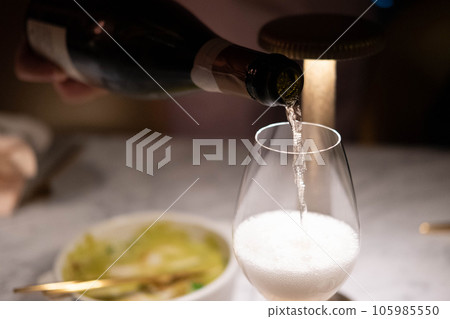 Man is pouring champagne in the glass 105985550