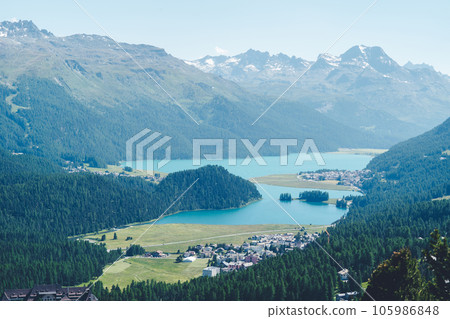 Aerial view to the city St. Morirz and lake, on sunny summer day, overlook of Engadin valley in summer with Lake Silvaplana, Switzerland. Aerial view to the city St. Morirz and lake, on sunny summer day, overlook of Engadin valley in summer with Lake Silvaplana, Switzerland. 105986848