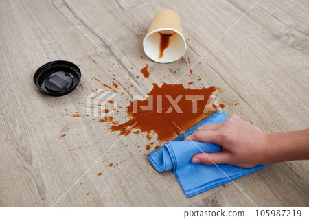 Paper cup of coffee fell on laminate, coffee spilled on floor. 105987219