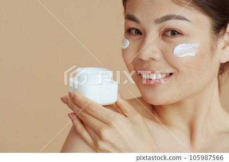 Portrait of modern woman with facial cream jar 105987566