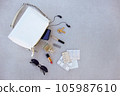 White handbag open with pills and women's accessories. 105987610