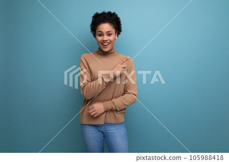 young pretty latin woman with curly hair smiles with a wide smile on the background with copy space 105988418