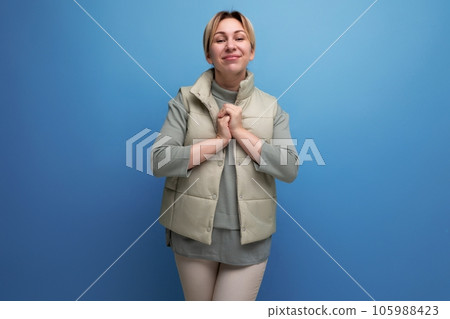 portrait of a blond young woman in love in spring clothes pressing her hands to her chest on a 105988423