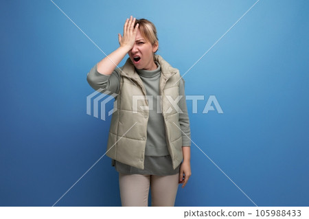 blonde 30s woman upset because of stupidity on studio blue background 105988433