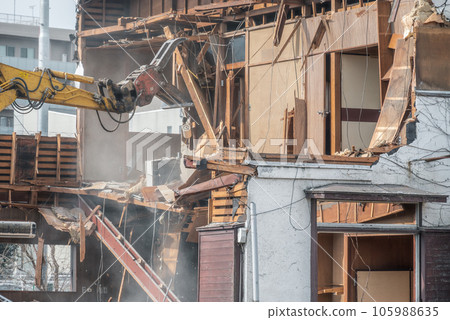 Heavy machinery dismantling the interior of a wooden house 105988635