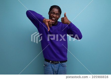 portrait of a doubtful dark-skinned european young adult in a blue hoodie and jeans isolated on a portrait of a doubtful dark-skinned european young adult in a blue hoodie and jeans isolated on a 105988816