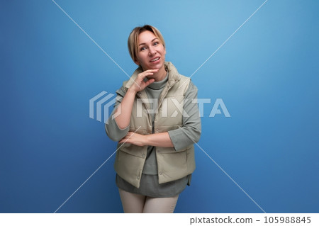 well-groomed blond youthful woman in spring clothes isolated on blue background well-groomed blond youthful woman in spring clothes isolated on blue background 105988845