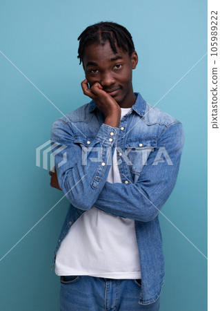 portrait of a shy young african man with dreadlocks in a denim jacket posing thoughtfully portrait of a shy young african man with dreadlocks in a denim jacket posing thoughtfully 105989222