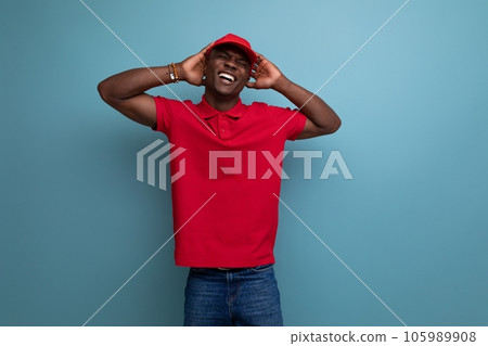corporate color. handsome african man wearing red t-shirt and cap on background with copy space corporate color. handsome african man wearing red t-shirt and cap on background with copy space 105989908