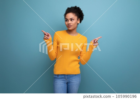adorable young latin woman with afro hair showing hands in different directions on studio background adorable young latin woman with afro hair showing hands in different directions on studio background 105990196