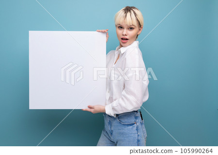 a young positive caucasian woman with a short haircut is dressed in a white shirt and jeans holding a young positive caucasian woman with a short haircut is dressed in a white shirt and jeans holding 105990264