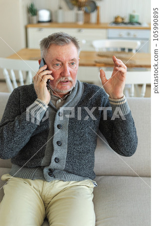 Happy middle aged senior man talking on smartphone with family friends. Older mature grandfather with cell phone talking with grown up children, resting at home. Older generation modern tech usage Happy middle aged senior man talking on smartphone with family friends. Older mature grandfather with cell phone talking with grown up children, resting at home. Older generation modern tech usage 105990895