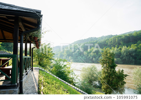 Porch of a wooden house in the forest on the river bank 105991075