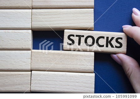 Stocks symbol. Concept word Stocks on wooden blocks. businessman hand. Beautiful deep blue background. Business and Stocks concept. Copy space. 105991099