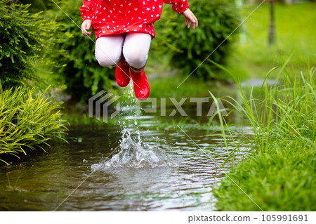 Kids in puddle in autumn rain. Waterproof wear 105991691
