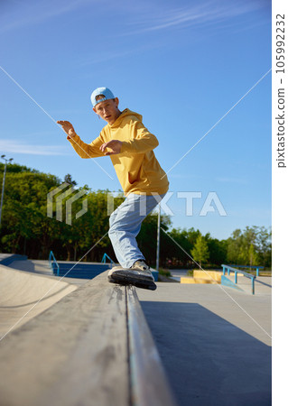 Talented teen guy roller skating making trick on border 105992232