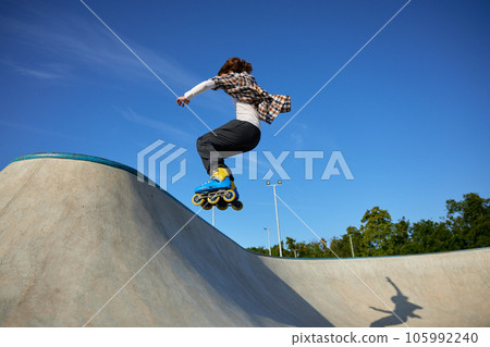 Teenager guy riding roller skates performing speed moving Teenager guy riding roller skates performing speed moving 105992240
