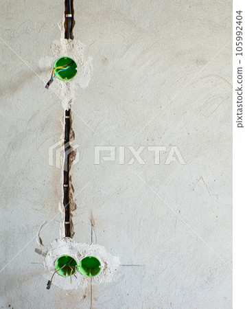 Plastic backbox for sockets or switches inserted into the drilled holes on wall Plastic backbox for sockets or switches inserted into the drilled holes on wall 105992404