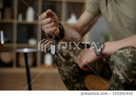 Closeup military person holding fighter dog tag badge in hand 105992450