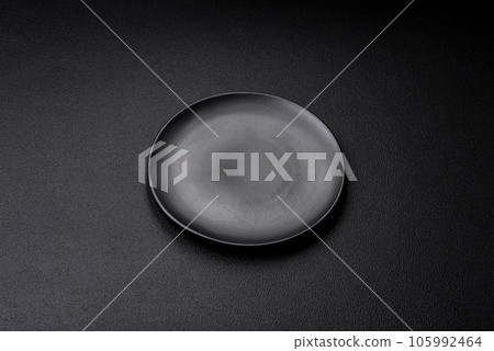 Empty black plate over dark stone background with copy space Empty black plate over dark stone background with copy space 105992464