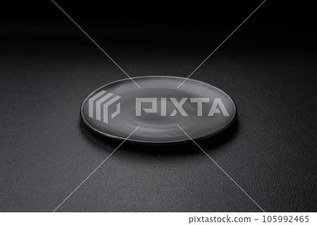 Empty black plate over dark stone background with copy space 105992465