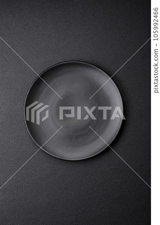 Empty black plate over dark stone background with copy space 105992466