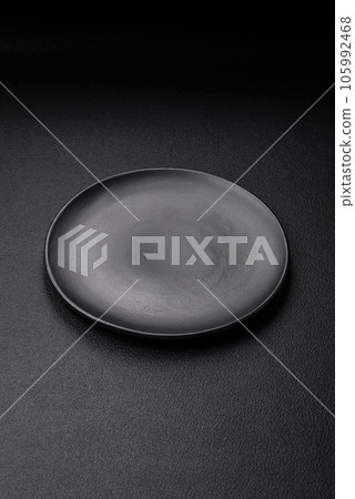 Empty black plate over dark stone background with copy space Empty black plate over dark stone background with copy space 105992468