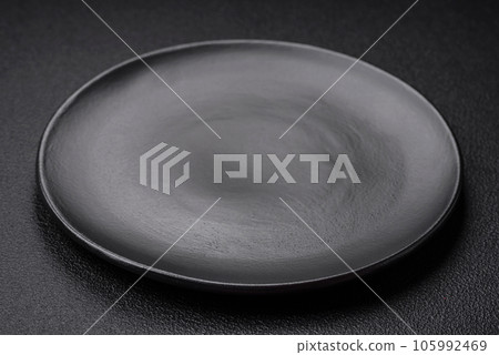 Empty black plate over dark stone background with copy space Empty black plate over dark stone background with copy space 105992469