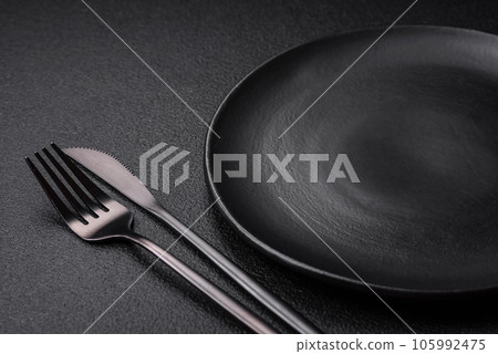 Empty black plate over dark stone background with copy space Empty black plate over dark stone background with copy space 105992475