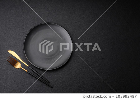 Empty black plate over dark stone background with copy space 105992487