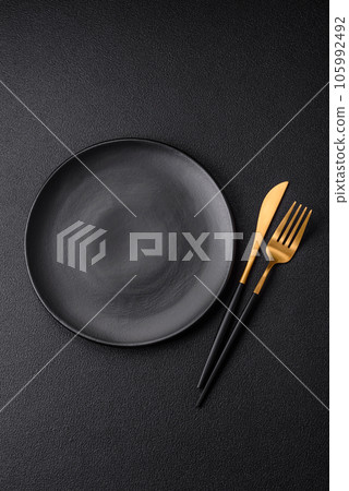 Empty black plate over dark stone background with copy space 105992492