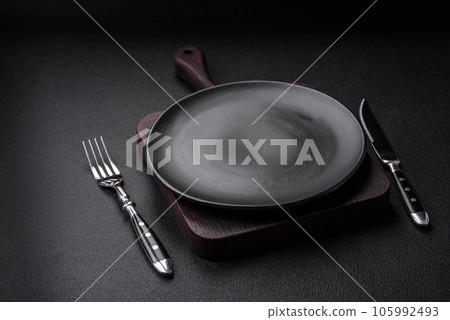 Empty black plate over dark stone background with copy space 105992493