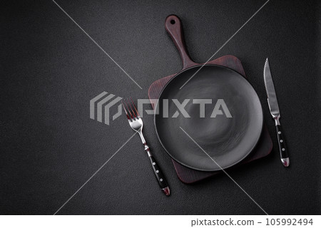 Empty black plate over dark stone background with copy space 105992494