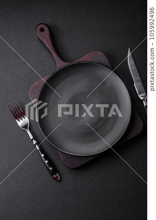 Empty black plate over dark stone background with copy space 105992496