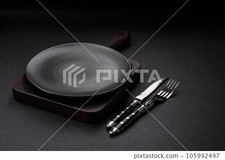 Empty black plate over dark stone background with copy space 105992497