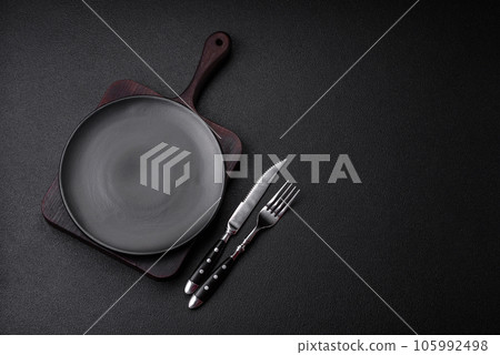 Empty black plate over dark stone background with copy space 105992498