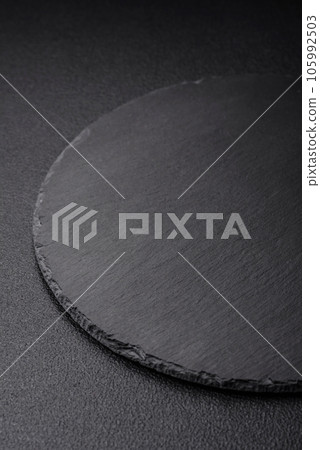 Empty black plate over dark stone background with copy space Empty black plate over dark stone background with copy space 105992503