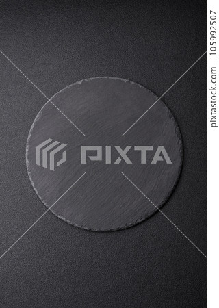 Empty black plate over dark stone background with copy space 105992507