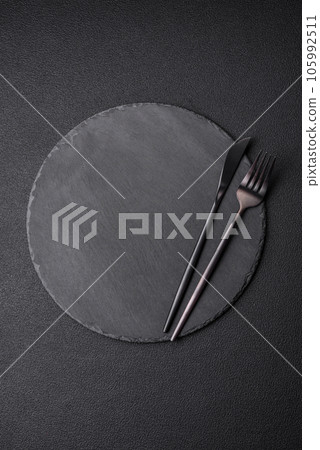 Empty black plate over dark stone background with copy space 105992511