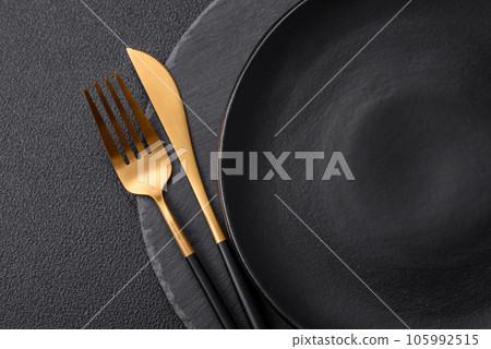 Empty black plate over dark stone background with copy space 105992515