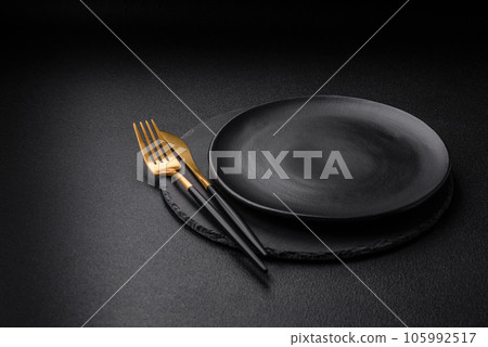 Empty black plate over dark stone background with copy space 105992517