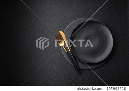 Empty black plate over dark stone background with copy space 105992518