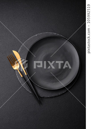 Empty black plate over dark stone background with copy space Empty black plate over dark stone background with copy space 105992519