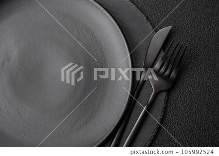 Empty black plate over dark stone background with copy space Empty black plate over dark stone background with copy space 105992524